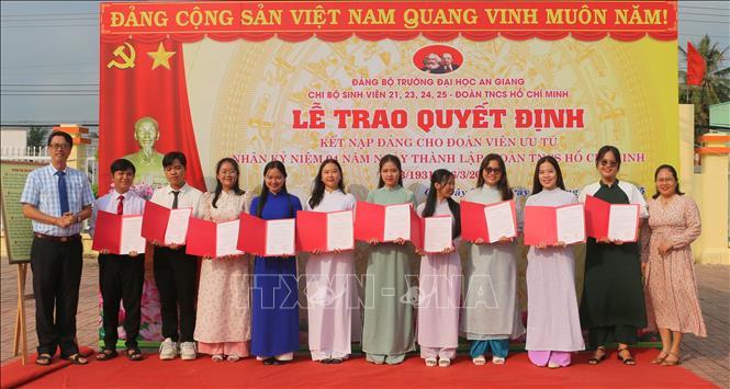 Đại diện Chi bộ 24 và 25 thuộc Đảng bộ Trường Đại học An Giang (Đại học Quốc gia Thành phố Hồ Chí Minh) trao quyết định kết nạp đảng viên cho các sinh viên ưu tú. Ảnh: Công Mạo-TTXVN