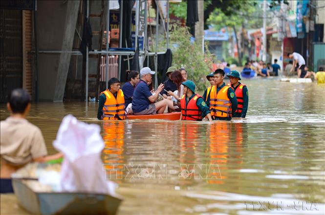 Lực lượng quân đội và dân quân tự vệ xã Bát Tràng, huyện Gia Lâm (Hà Nội) giúp người dân di chuyển và tiếp tế nhu yếu phẩm do ảnh hưởng của mưa lũ (9/2024). Ảnh: Thanh Tùng – TTXVN