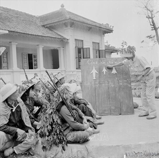 Đồng chí Nguyễn Xuân Tảo, bộ đội phục viên, trung đội trưởng đội dân quân tự vệ bệnh viện Hà Đông chia sẻ kinh nghiệm bắn máy bay cho tổ săn máy bay của bệnh viện. Ảnh: Thanh Tụng – TTXVN
