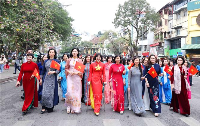 More than 1,000 women wearing “ao dai” (Vietnamese traditional dress) participate in a parade at Hoan Kiem Lake walking street in Hanoi on March 29. Photo: VNA