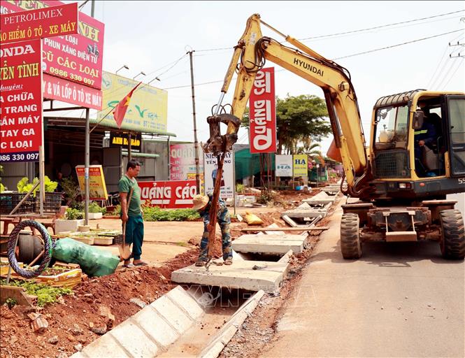 Đơn vị thi công đang hoàn thiện hệ thống thoát nước trên đoạn đường qua xã Đắk Nia, thành phố Gia Nghĩa, tỉnh Đắk Nông. Ảnh: Ngọc Minh – TTXVN