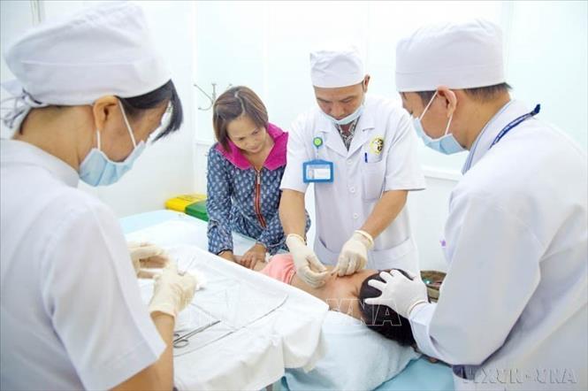 Bác sĩ Bệnh viện Châm cứu Trung ương chuyển giao cho bác sĩ Viện Y dược học dân tộc Thành phố Hồ Chí Minh kỹ thuật cấy chỉ điều trị cho trẻ bệnh tự kỷ và thiểu năng não. Ảnh: Phương Vy-TTXVN.