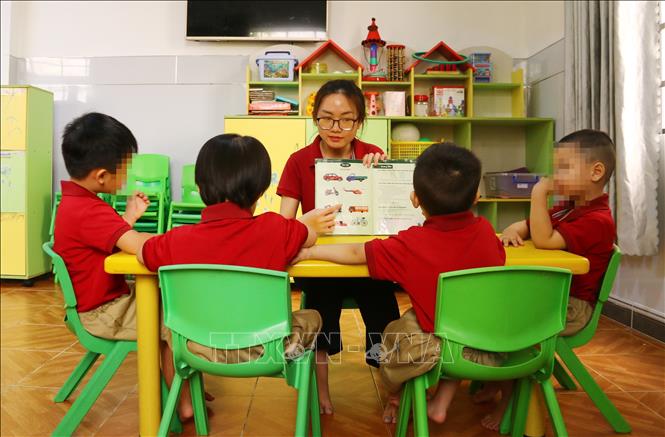 Giáo viên can thiệp trẻ tự kỷ theo nhóm giúp các bé nhận biết hình ảnh, giao tiếp, hòa nhập. Ảnh: Lê Xuân-TTXVN