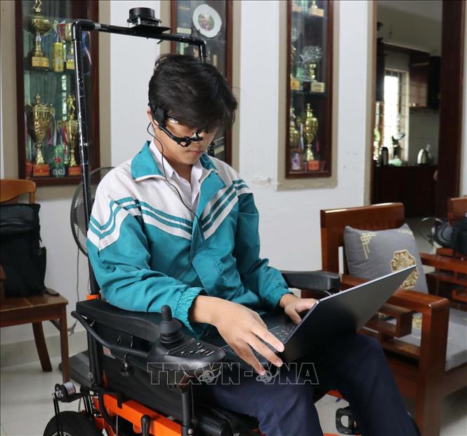 Em Cao Trung Quân đang chạy thử chiếc xe lăn thông minh dành cho người bị mắc bệnh xơ cứng teo cơ. Ảnh: Thanh Thuỷ-TTXVN