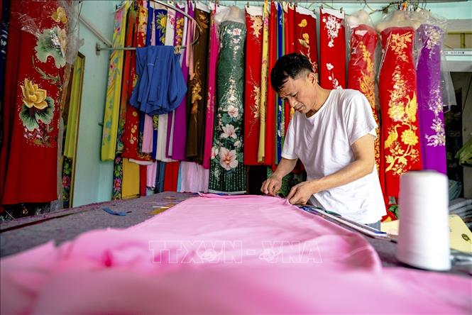 Các thế hệ làng nghề Trạch Xá vẫn miệt mài gìn giữ lối cắt may truyền thống. Ảnh: Khánh Hoà - TTXVN