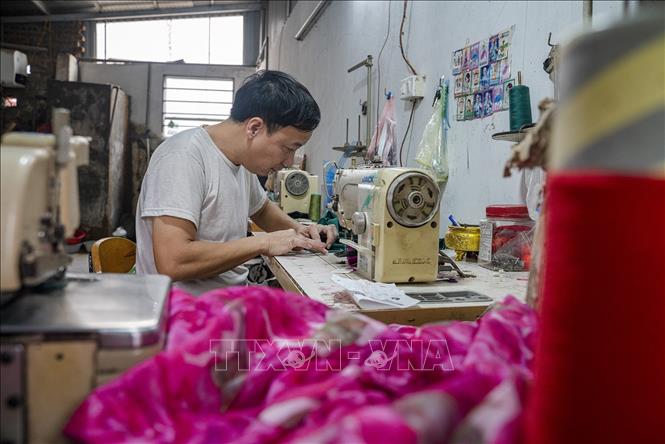 Từ nghìn năm nay, làng Trạch Xá đã nuôi dưỡng lớp lớp những người thợ may tài hoa, bằng tình yêu nghề và đôi bàn tay khéo léo, họ tạo ra những chiếc áo dài truyền thống tôn lên vẻ đẹp của người phụ nữ Việt Nam. Ảnh: Khánh Hoà - TTXVN 