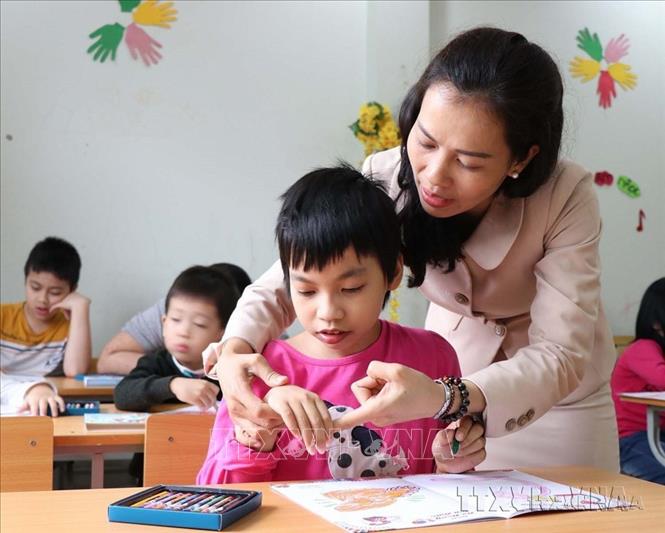 Cô giáo Đỗ Thị Nhị, Cơ sở mầm non chuyên biệt Bình Minh (phường Đồng Nguyên, thị xã Từ Sơn, tỉnh Bắc Ninh) chăm sóc trẻ tự kỷ. Ảnh: Thanh Thương - TTXVN