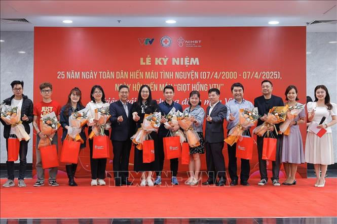 Ban tổ chức tặng hoa tri ân người hiến máu tình nguyện tiêu biểu. Ảnh: Minh Quyết - TTXVN