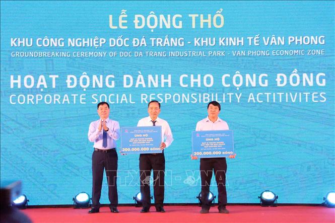 Đại diện chủ đầu tư dự án (bên trái) tặng tượng trưng 600 triệu đồng cho các quỹ xã hội của địa phương nơi xây dựng dự án. Ảnh: Tiên Minh - TTXVN