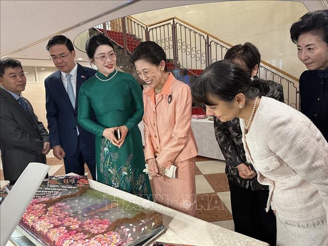 Thai Thu Hong, spouse of Vietnamese Ambassador to Japan Pham Quang Hieu, introduces a unique Vietnamese floral art performance—3D flower carving on jelly, to Princess Takamado and the wife of the Japanese Prime Minister Shigeru Ishiba. VNA Photo: Nguyễn Tuyến