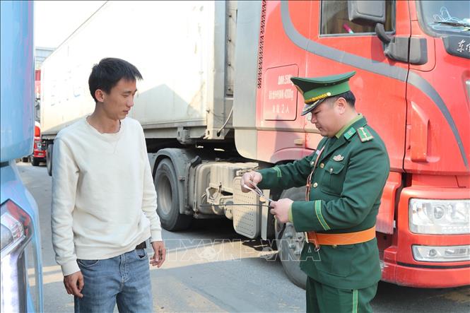 Bộ đội biên phòng cửa khẩu Chi Ma tra soát giấy tờ xe chở hàng qua biên giới. Ảnh: Quang Duy – TTXVN