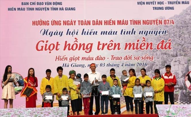 Lãnh đạo Ngân hàng NN&PTNT Viện Nam - Chi nhánh tỉnh Hà Giang trao tặng nhiều suất quà cho các bệnh nhân là người dân tộc thiểu số có hoàn cảnh đặc biệt khó khăn của Hà Giang tại ngày hội hiến máu tình nguyện “Giọt hồng trên miền đá” (2016). Ảnh: Minh Tâm - TTXVN.