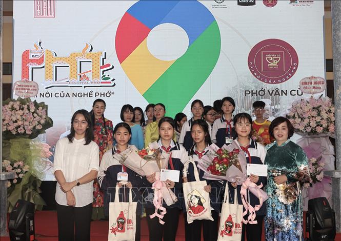 Trao thưởng cho học sinh đoạt giải Cuộc thi viết về nghề phở quê hương. Ảnh: Trần Việt - TTXVN 