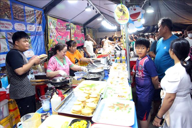 Người dân và du khách tham quan gian hàng bánh dân gian tại Lễ hội. Ảnh: Trung Kiên - TTXVN