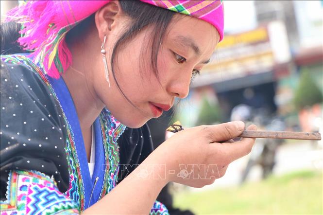 The beeswax needs to be heated to 70-80 degrees Celsius to prevent it from drying out during use. A Mong girl gently blowing on the pen to cool the beeswax to the right temperature. VNA Photo: Nguyễn Oanh