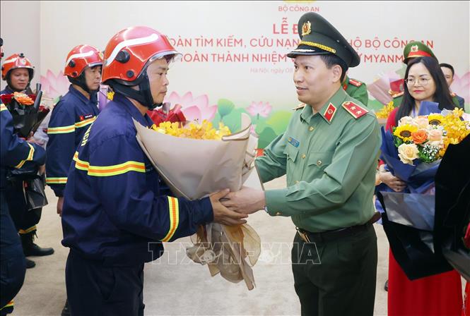 Trung tướng Lê Văn Tuyến, Thứ trưởng Bộ Công an tặng hoa chúc mừng cán bộ, chiến sĩ đoàn tìm kiếm, cứu nạn và cứu hộ Bộ Công an hoàn thành nhiệm vụ trở về từ Myanmar. Ảnh: Phạm Kiên - TTXVN 