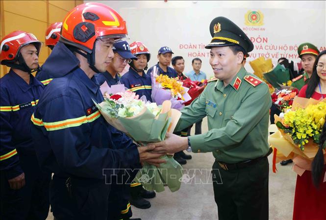 Trung tướng Lê Văn Tuyến, Thứ trưởng Bộ Công an tặng hoa chúc mừng cán bộ, chiến sĩ đoàn tìm kiếm, cứu nạn và cứu hộ Bộ Công an hoàn thành nhiệm vụ trở về từ Myanmar. Ảnh: Phạm Kiên - TTXVN 