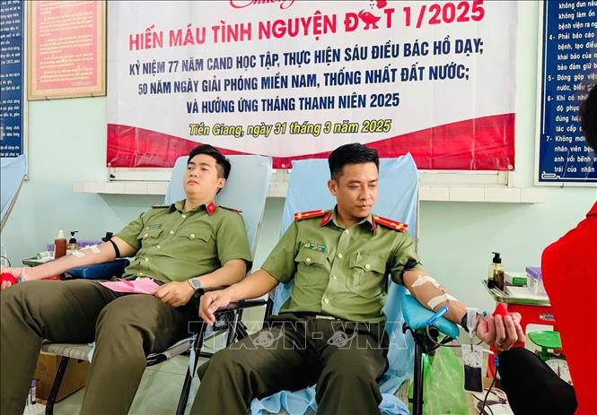 Thượng úy Nguyễn Thành Đạt (thứ hai, trái) tham gia hiến máu tình nguyện. Ảnh: TTXVN phát