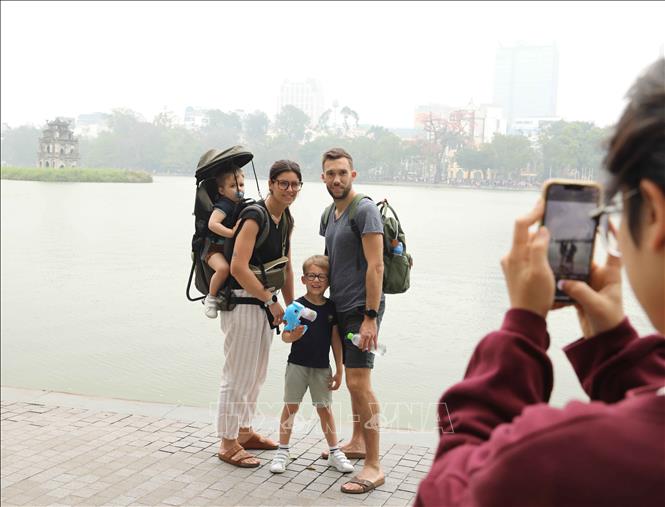 Foreign visitors check in on Hoan Kiem Lake in Hanoi. VNA Photo: Thành Phương