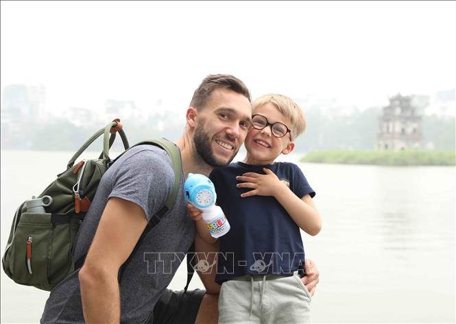 Foreign visitors check in on Hoan Kiem Lake in Hanoi. VNA Photo: Thành Phương