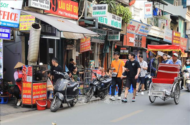 Vỉa hè vốn đã hẹp, lại thêm hàng hóa bày bán khiến người đi bộ chỉ còn cách đi xuống lòng đường, gây mất an toàn giao thông tại phố Hàng Bè, quận Hoàn Kiếm. Ảnh: Thành Phương – TTXVN