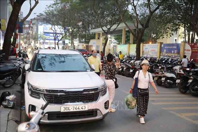Người dân phải đi bộ dưới lòng đường trên phố Hoàng Như Tiếp, quận Long Biên vì vỉa hè không còn một khoảng trống, gây nguy hiểm và mất an toàn giao thông. Ảnh: Thành Phương-TTXVN