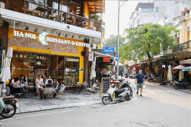 Vỉa hè tại phố Thuốc Bắc bị quán kinh doanh ăn uống chiếm dụng, khiến người đi bộ phải đi dưới lòng đường. Ảnh: Lê Đông-TTXVN