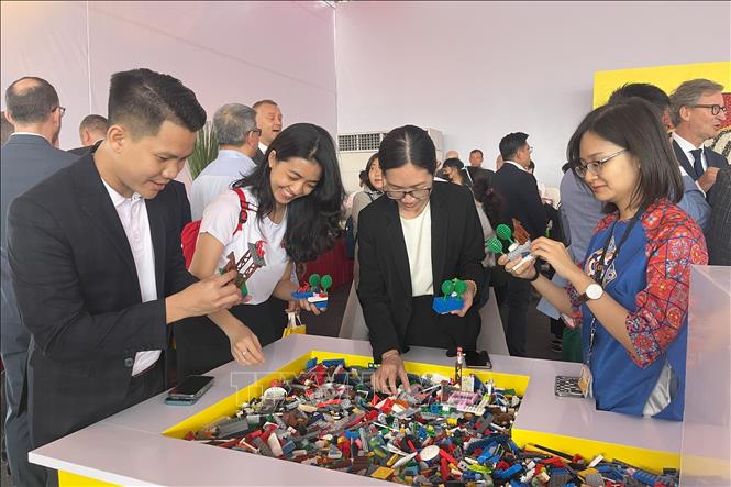 Delegates experience LEGO pieces. VNA Photo: Văn Hướng 