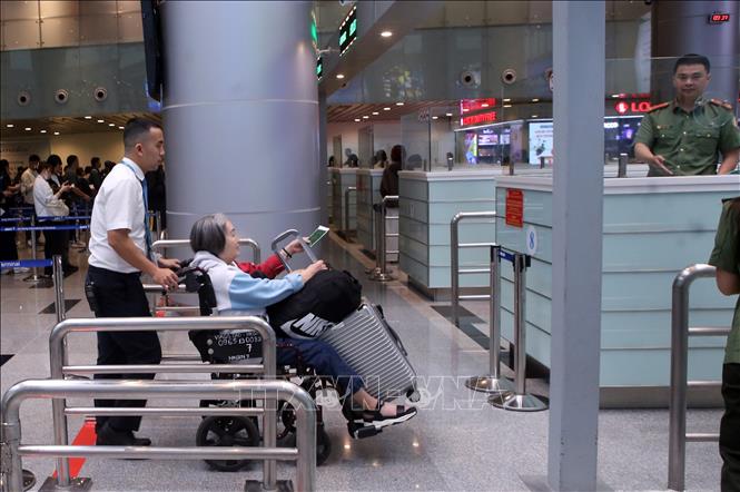 Nhân viên sân bay quốc tế Đà Nẵng hỗ trợ giúp hành khách quốc tế di chuyển làm thủ tục nhập cảnh. Ảnh: Trần Lê Lâm - TTXVN