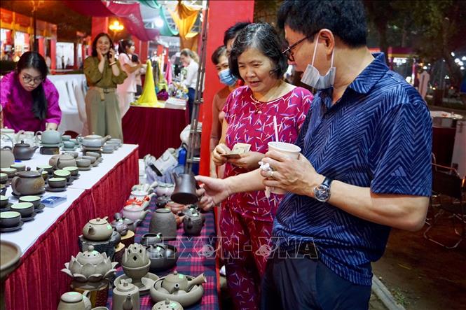 Khách tham quan gian hàng gốm sứ truyền thống Bát Tràng. Ảnh: Tú Anh/TTXVN phát