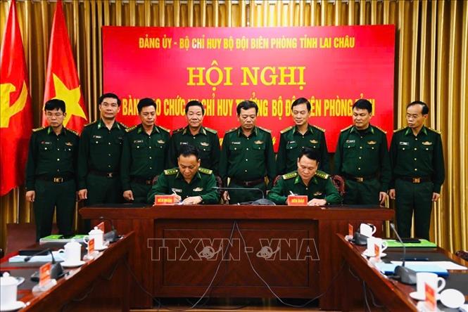 Thượng tá Trương Minh Đức và Đại tá Triệu Quốc Nguậy (hàng ngồi, từ trái sang phải) ký biên bản bàn giao nhiệm vụ Chỉ huy trưởng Bộ đội Biên phòng tỉnh Lai Châu. Ảnh: TTXVN phát