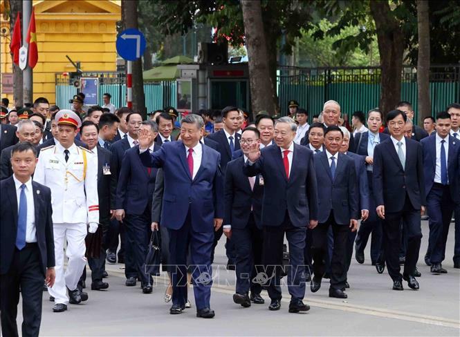 Tổng Bí thư Tô Lâm và Tổng Bí thư, Chủ tịch nước Trung Quốc Tập Cận Bình vẫy chào quần chúng nhân dân trên đường di chuyển từ Phủ Chủ tịch sang Trụ sở Trung ương Đảng. Ảnh: Phạm Kiên - TTXVN