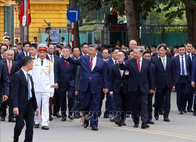 Tổng Bí thư Tô Lâm và Tổng Bí thư, Chủ tịch nước Trung Quốc Tập Cận Bình vẫy chào quần chúng nhân dân trên đường di chuyển từ Phủ Chủ tịch sang Trụ sở Trung ương Đảng. Ảnh: Phạm Kiên - TTXVN