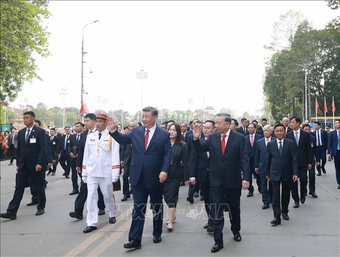 Tổng Bí thư Tô Lâm và Tổng Bí thư, Chủ tịch nước Trung Quốc Tập Cận Bình vẫy chào quần chúng nhân dân trên đường di chuyển từ Phủ Chủ tịch sang Trụ sở Trung ương Đảng. Ảnh: Thống Nhất - TTXVN