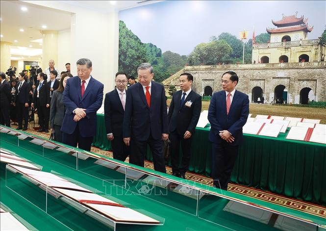 Party General Secretary To Lam and  General Secretary of the Communist Party of China Central Committee and President of China Xi Jinping witness the display of cooperation documents between the two countries in Hanoi on April 14. VNA Photo