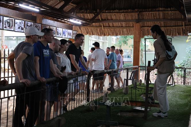 Du khách nước ngoài nghe hướng dẫn viên thuyết minh về tác dụng của hầm chông trong chiến đấu. Ảnh: Thu Hương - TTXVN    