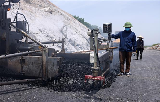 Nhà thầu tăng tốc thảm những mét nhựa cuối cùng trên tuyến cao tốc Bùng – Vạn Ninh. Ảnh: Quốc Khánh – TTXVN