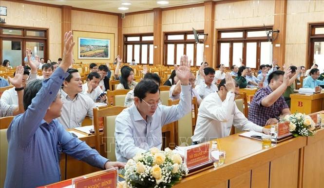 Các đại biểu biểu quyết thông qua Đề án sáp nhập đơn vị hành chính cấp xã. Ảnh: TTXVN phát