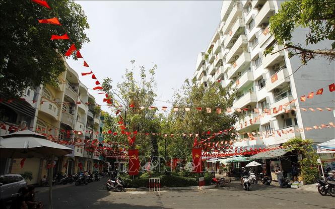 Chung cư 10A Trần Nhật Duật (Quận 1, Thành phố Hồ Chí Minh) treo cờ rực rỡ chào mừng 50 năm Ngày Giải phóng miền Nam, thống nhất đất nước. Ảnh: Thanh Vũ - TTXVN