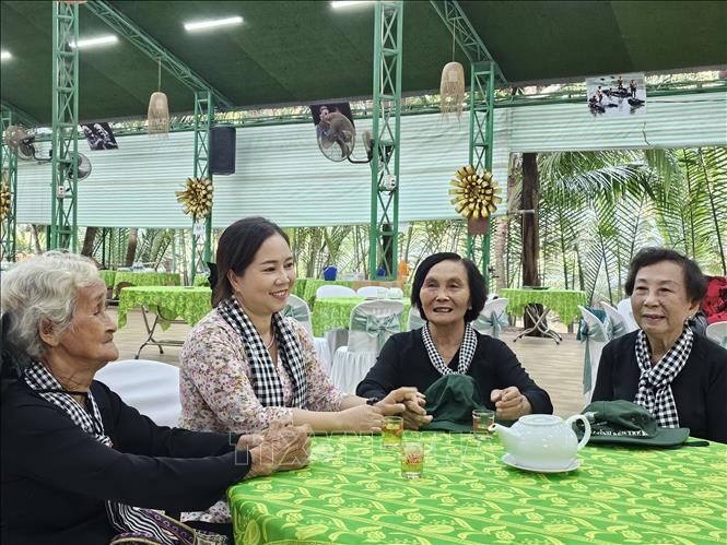 Chủ tịch Hội Liên hiệp phụ nữ tỉnh Bến Tre Nguyễn Thị Kim Thoa (thứ hai từ trái sang) trò chuyện cùng các chiến sĩ Đội quân tóc dài năm xưa. Ảnh: Chương Đài - TTXVN
