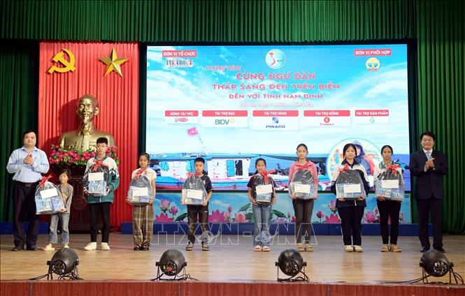 Đại diện ban tổ chức tặng quà cho học sinh là con em ngư dân có hoàn cảnh khó khăn nhưng vươn lên học giỏi. Ảnh: Thái Thuần - TTXVN