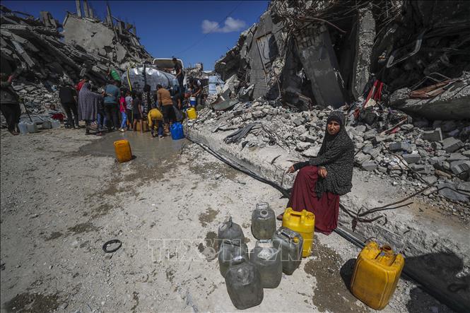 Người dân Palestine xếp hàng chờ lấy nước sinh hoạt tại trại tị nạn ở Dải Gaza. Ảnh: THX/TTXVN