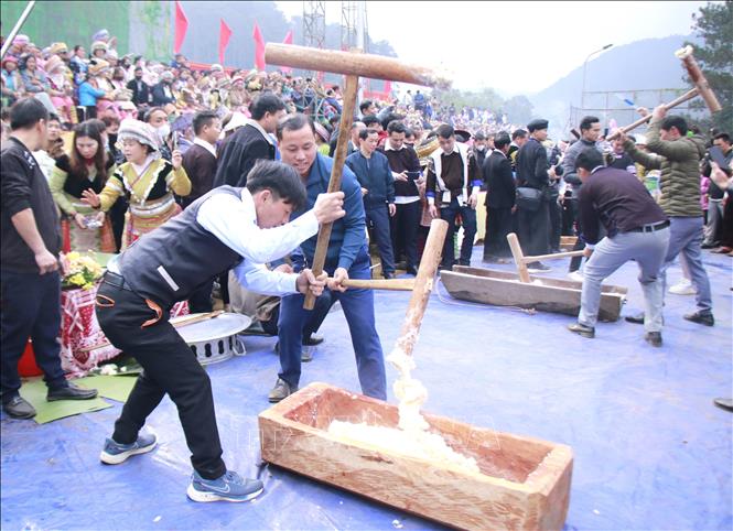 Visitors enjoy sticky rice cake pounding activities with Mong people in Yen Bai province. VNA Photo
