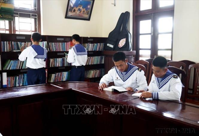Các chiến sĩ Trường Sa đọc sách sau giờ huấn luyện. Hiện các đơn vị ở Trường Sa đều được trang bị tủ sách với số lượng lớn các đầu sách về các lĩnh vực phục vụ nhu cầu đọc của cán bộ, chiến sĩ. Ảnh: Hồng Đạt - TTXVN