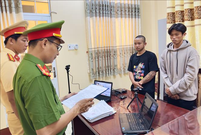 Cơ quan Cảnh sát điều tra tống đạt quyết định khởi tố bị can, lệnh cấm đi khỏi nơi cư trú đối với Võ Duy Khang (thứ 2, phải) và Phạm Văn Ý (phải). Ảnh: Trọng Nguyễn - TTXVN phát 