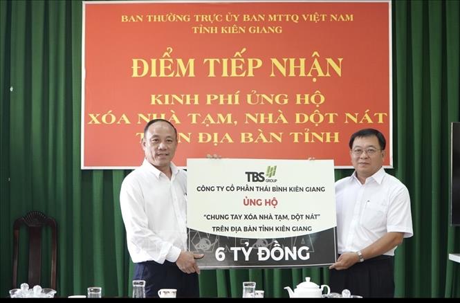 Phó Tổng Giám đốc Tập đoàn Thái Bình Cao Thanh Lương (trái) trao bảng biểu trưng ủng hộ chương trình xóa nhà tạm, nhà dột nát tại tỉnh Kiên Giang. Ảnh: Lê Sen – TTXVN