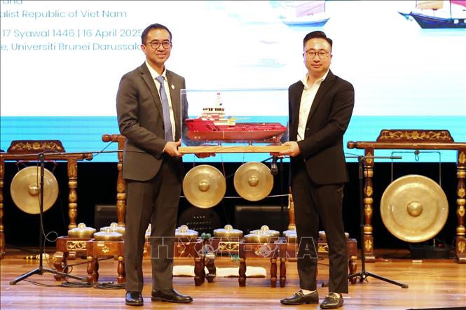 Lãnh đạo công ty HADUCO (phải) trao quà lưu niệm cho Tiến sỹ Hazri, Phó Hiệu trưởng trường UBD. Ảnh: TTXVN phát.
