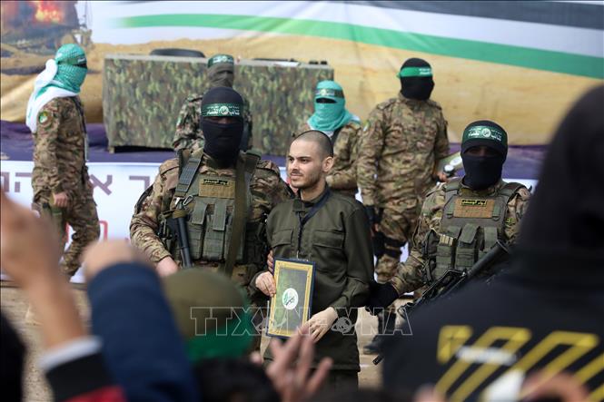 Lữ đoàn Al-Qassam, một cánh quân của Phong trào Hamas, trao trả con tin Israel cho Uỷ ban Chữ thập đỏ quốc tế tại trại tị nạn Nuseirat ở miền Trung Dải Gaza, ngày 22/2/2025. Ảnh: THX/TTXVN