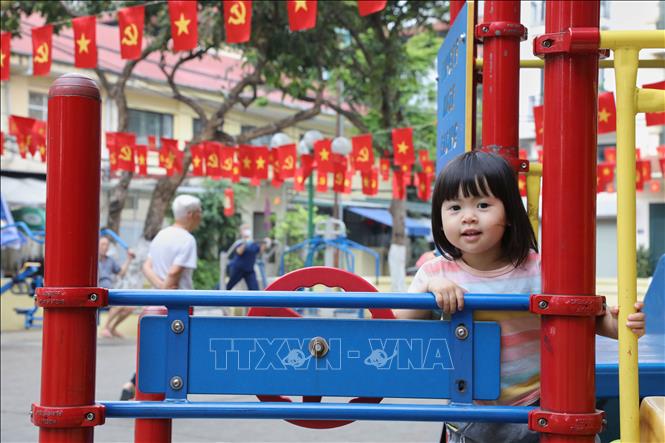 Bé vui vì khu nhà mình treo rất nhiều cờ Tổ Quốc. Ảnh: Lê Đông - TTXVN