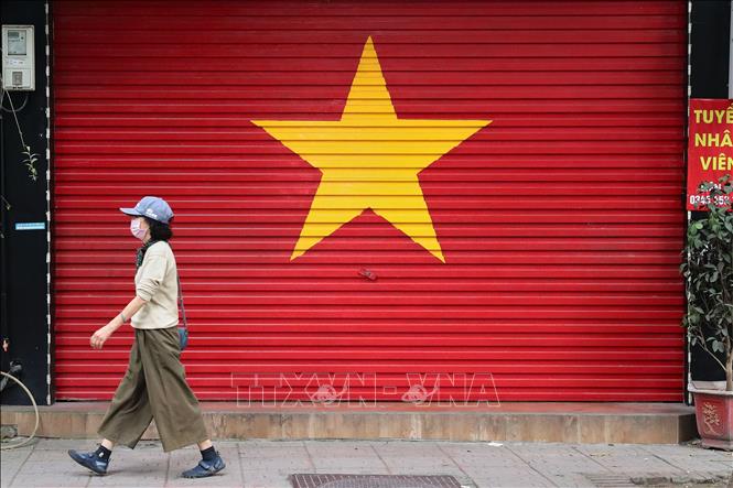 Cờ Tổ quốc xuất hiện tại nhiều mặt tiền cửa hàng ở Hà Nội, thể hiện niềm tự hào dân tộc. Ảnh: Lê Đông - TTXVN